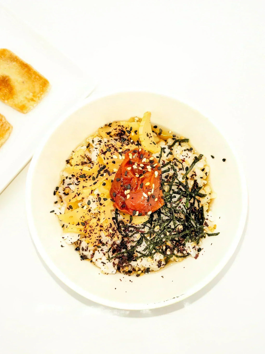 Un bol d'ochazuke garni avec une prune umeboshi et des algues en flocons | Eat in Japan Épicerie Japonaise